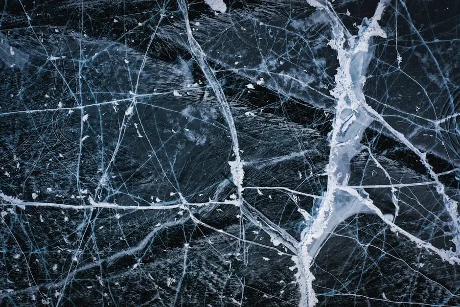 Aerial view of intricate ice cracks on Lake Baikal's surface, showcasing winter's beauty.
